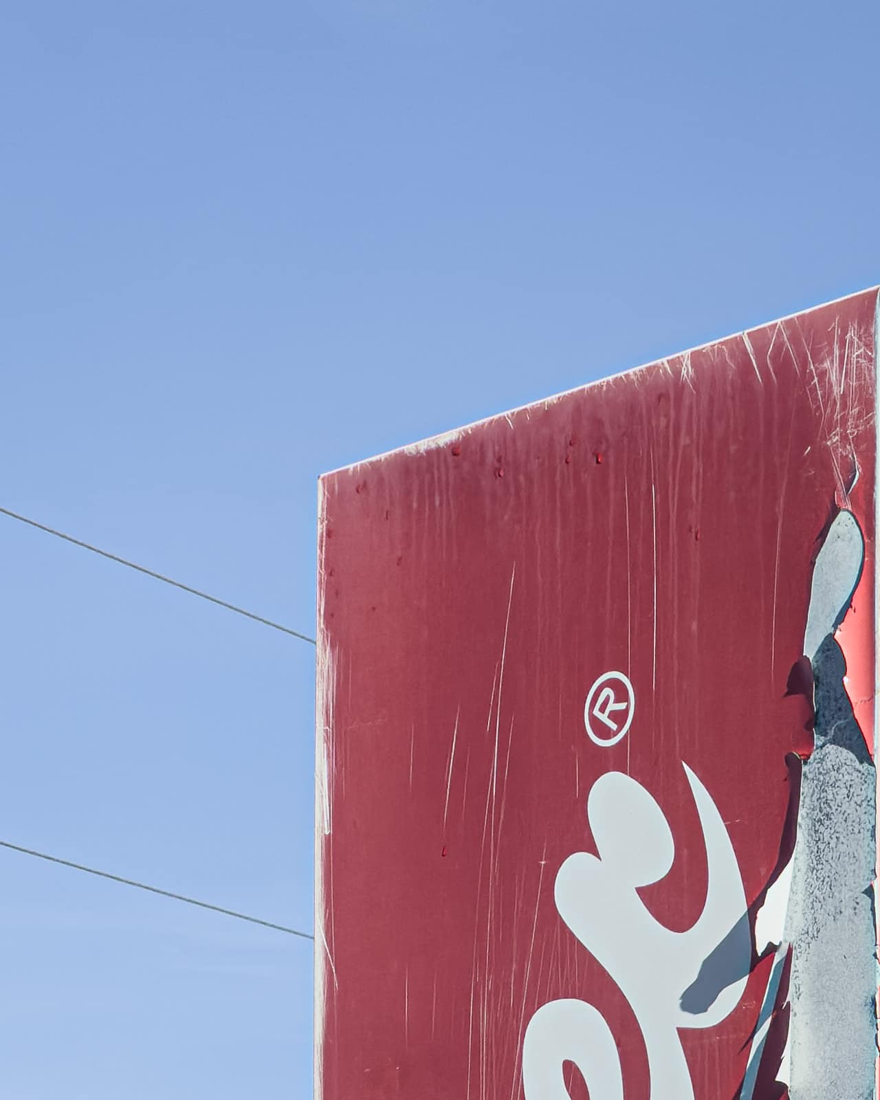 Vertical fragment of a red Coca-Cola vending machine against blue sky in Zeltweg